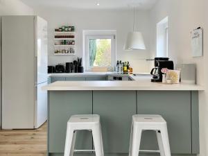 a kitchen with a counter and two stools in it at StylishHomes NEST - A Cosy Adventure in Frauental an der Lassnitz 