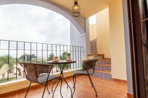 balkon ze stołem i krzesłami oraz oknem w obiekcie Ático con terraza-solárium y piscina 4-6 personas WIFI A/C w mieście Roda