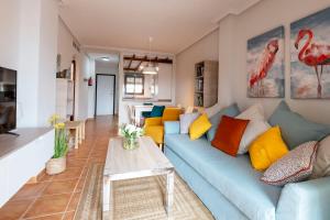 salon z niebieską kanapą i stołem w obiekcie Ático con terraza-solárium y piscina 4-6 personas WIFI A/C w mieście Roda