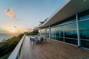 a balcony of a house with a table and chairs at Happy Days Villa C in Fajardo +30 photos
