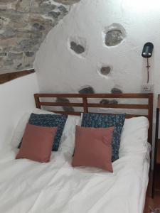 1 dormitorio con 1 cama blanca y 2 almohadas en Cantina antica en Colonno