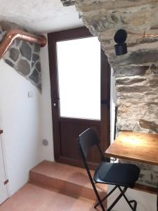 een stoel in een kamer met een stenen muur bij Cantina antica in Colonno