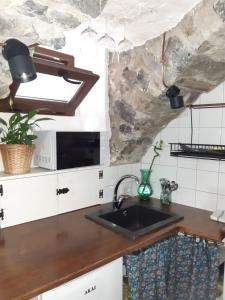 uma cozinha com um lavatório e um micro-ondas em Cantina antica em Colonno