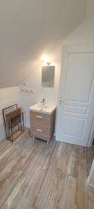 een badkamer met een wastafel, een spiegel en een deur bij Appartement 4 personnes à 100 m de la plage in Berck-sur-Mer