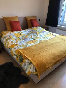 a bed with a colorful blanket on top of it at Trendy & ruim appartement centum Oostende in Ostend