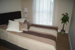 a bedroom with a large bed with a potted plant at Apartament in Ostróda