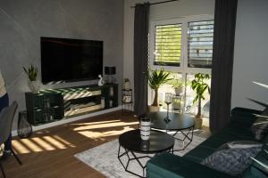 a living room with a green couch and a tv at Apartament in Ostróda