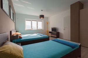 - une chambre avec 2 lits et une télévision dans l'établissement Villa Nada, à Ohrid