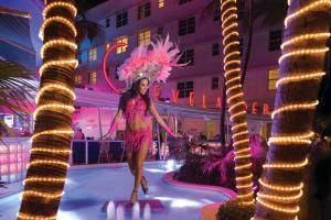a woman in a pink dress standing in front of a building at Essex House Hotel in Miami Beach