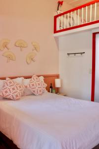 a bedroom with a white bed with a loft at La Cabaña Ecohotel - Valle del Cocora in Salento