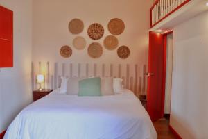 a bedroom with a white bed and a red door at La Cabaña Ecohotel - Valle del Cocora in Salento