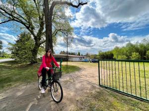 une femme qui descend en vélo dans une allée dans l'établissement Domek nad Wartą, à Międzychód