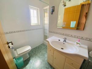 a bathroom with a sink and a toilet and a mirror at Casa Da Anita in Sagres