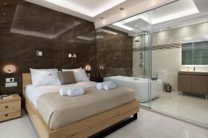 Rhodes SkyLine Suites في إيكسيا: غرفة نوم بسرير كبير وحوض استحمام