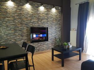 a living room with a tv on a brick wall at Olympus House in Litochoro