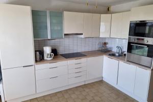 uma cozinha branca com armários e electrodomésticos brancos em 39m For 4 Residence With Pool Near Beach em La Grande-Motte