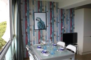 uma mesa de jantar com um pássaro na parede em 39m For 4 Residence With Pool Near Beach em La Grande-Motte