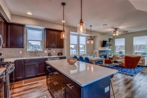 a kitchen with wooden cabinets and a living room at NEW Tri-Level Home with Ocean View and 3 En-Suite Bedrooms! in Depoe Bay