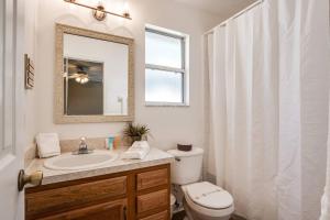 a bathroom with a sink and a toilet and a mirror at Honey Bee Hideaway in Fleming Island +42 photos