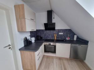 eine Küche mit weißen Schränken und einer schwarzen Arbeitsplatte in der Unterkunft New & Modern Apartment near Düsseldorf in Willich