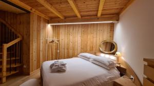 a bedroom with a bed with a mirror on the wall at Baita Pra Petina Pale di San Martino in Siror