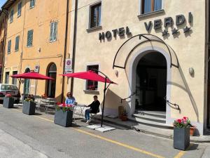 un par de personas sentadas fuera del patio de un hotel en Hotel Caffè Verdi - 24 hours Reception, en Pisa
