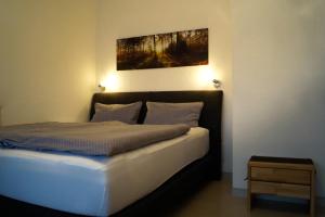 a bedroom with a bed with a painting on the wall at Kuckuckstraum in Schonwald im Schwarzwald