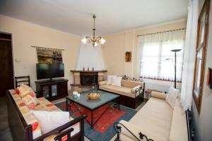 een woonkamer met 2 banken en een tv bij Traditional beach house in Sozopoli