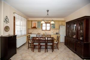 een keuken met een tafel en stoelen en een koelkast bij Traditional beach house in Sozopoli