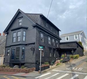 a black house on the corner of a street at Crew's Quarters Boarding House - Caters to Men in Provincetown