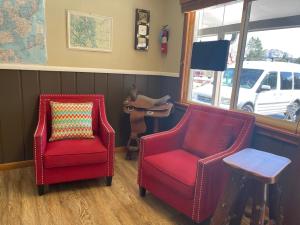 - deux chaises rouges et un oreiller dans la chambre dans l'établissement Saddle & Surrey Motel, à Estes Park