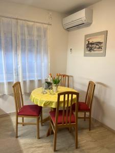 mesa de comedor con mantel amarillo y sillas en Stara Jezica Apartments with WiFi, en Liubliana