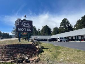 a sign for a motel in front of a parking lot at Saddle & Surrey Motel in Estes Park