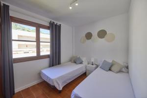 a bedroom with two beds and a window at Nura Houses Apartment Magaluf 1 in Magaluf