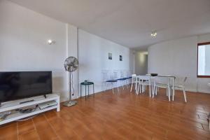 a living room with a television and a table and chairs at Nura Houses Magaluf Apartment in Magaluf +33 photos