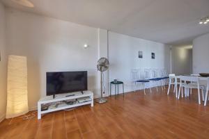 Il comprend un salon doté d'une télévision et d'une table avec des chaises. dans l'établissement Nura Houses Apartment Magaluf 1, à Magaluf