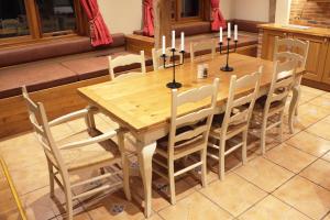 a wooden table and chairs with candles on it at The Coach House Barn - Valley Farm in Sudbourne