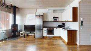 a kitchen with white appliances and a wooden floor at Saimaa Marina Garden Apartments in Lappeenranta