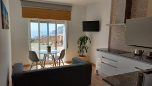 una cucina e un soggiorno con tavolo e sedie di Amazing view over the sea and village a Nazaré