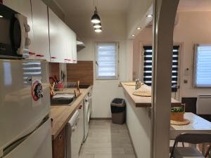 a kitchen with white cabinets and a counter top at Villa les palmiers -Stretta di i mandarini in Lucciana