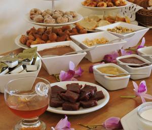 a table topped with lots of different types of food at Pousada Ouro de Minas in Tiradentes