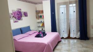 a bedroom with a pink bed with a purse on it at B&B Regina Elena in Pignola