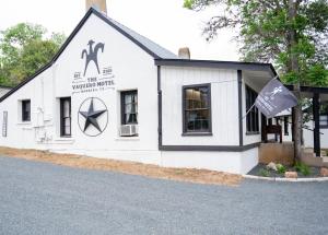 um edifício branco com um cartaz em THE VAQUERO MOTEL em Bandera