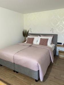 1 dormitorio con 1 cama grande con sábanas y almohadas rosas en Ami's House Castle View en Bled