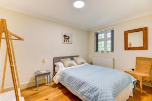 1 dormitorio con cama, espejo y silla en Redhill town centre apartment by Livingo, en Redhill
