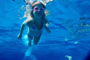 une fille en maillot de bain et lunettes de soleil nageant dans l'eau dans l'établissement Tal Affiliated by Fergus, à El Arenal