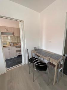 a dining room with a table and chairs and a kitchen at Apartman Jovana 2 in Jagodina