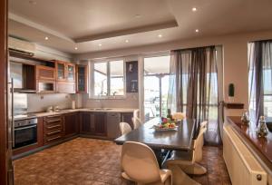 cocina y comedor con mesa y sillas en Akrata's Elegant Luxury Suite, en Akráta