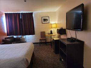 ein Hotelzimmer mit Bett und Flachbildfernseher in der Unterkunft Roadking Inns Motel in Calgary