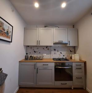 a kitchen with white cabinets and a stove at M37 x Fabryczna in Limanowa
